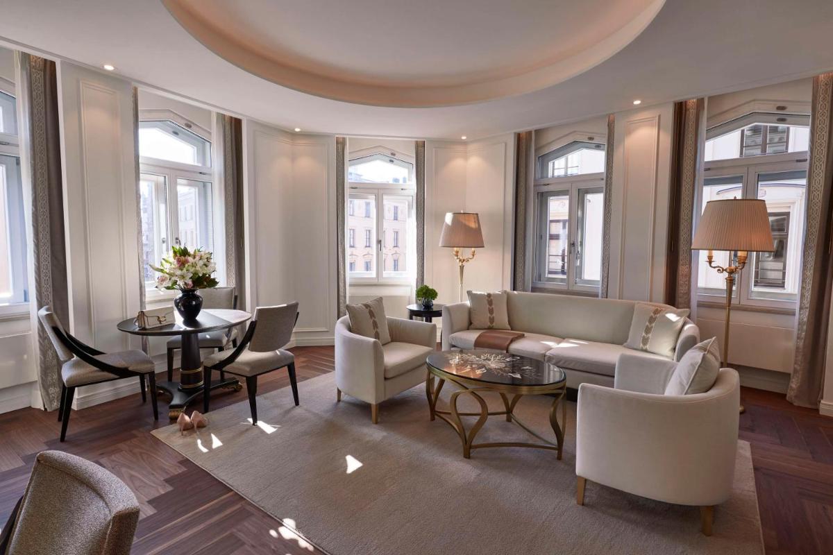 ein Wohnzimmer mit einer Couch und Stühlen und einem Tisch in der Unterkunft Vier Jahreszeiten Kempinski München in München ein Wohnzimmer mit einer Couch und Stühlen und einem Tisch in der Unterkunft Vier Jahreszeiten Kempinski München in München