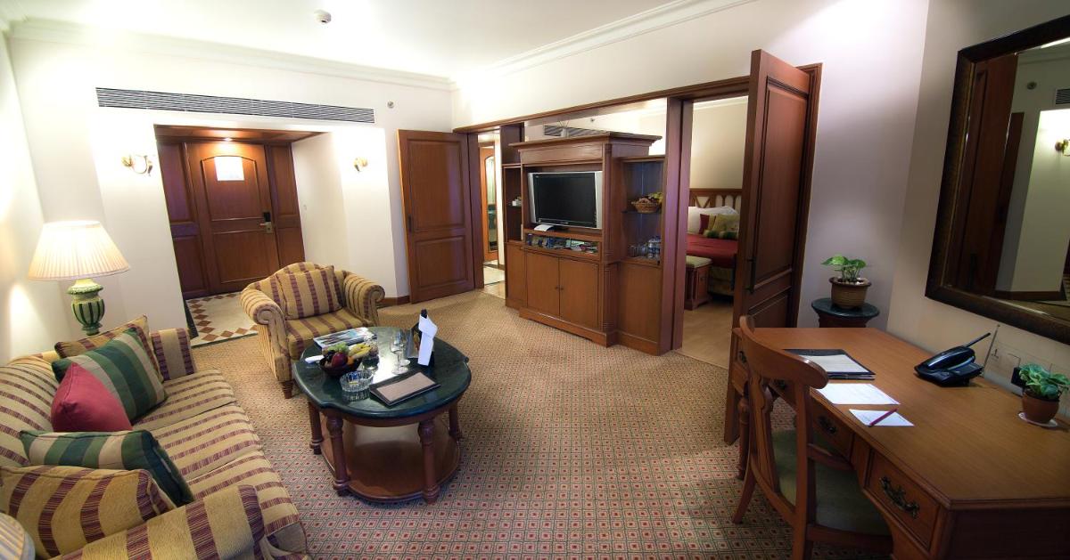 a living room with a couch and a table at The Orchid Hotel Mumbai Vile Parle in Mumbai