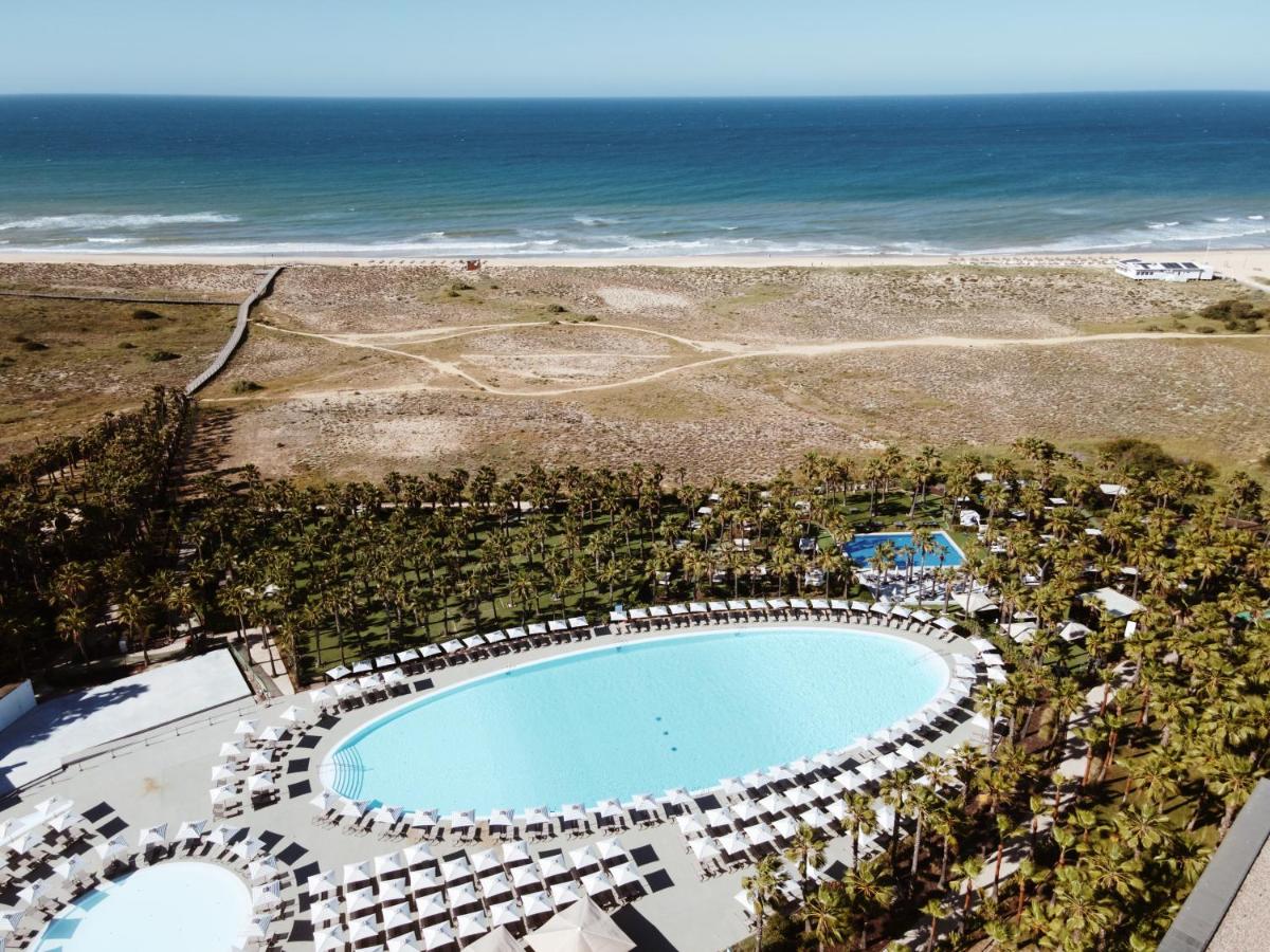 uma vista aérea de uma piscina e da praia em Wine & Books by the Sea, Algarve Resort em Albufeira uma vista aérea de uma piscina e da praia em Wine & Books by the Sea, Algarve Resort em Albufeira