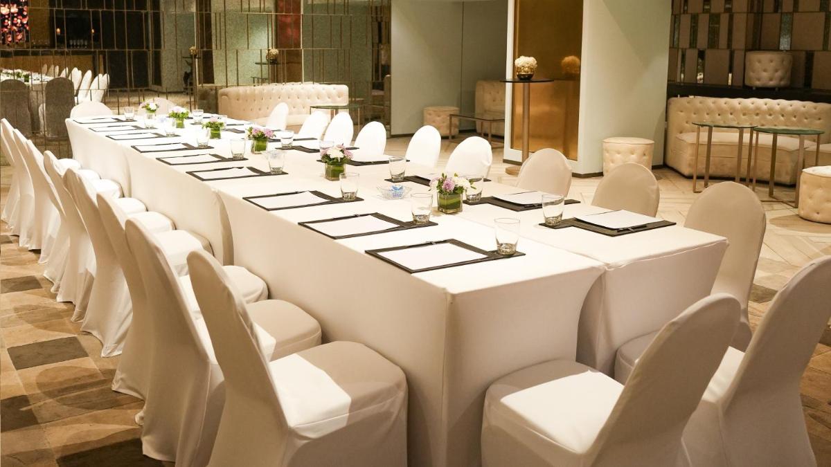 a long table with white chairs in a room at InterContinental Marine Drive Mumbai by IHG in Mumbai