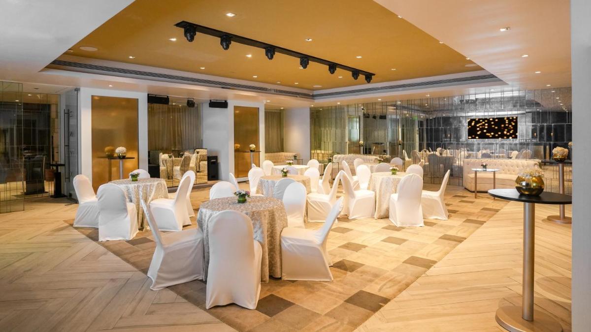 a banquet hall with white chairs and tables and a room filled with tables and chairs at InterContinental Marine Drive Mumbai by IHG in Mumbai