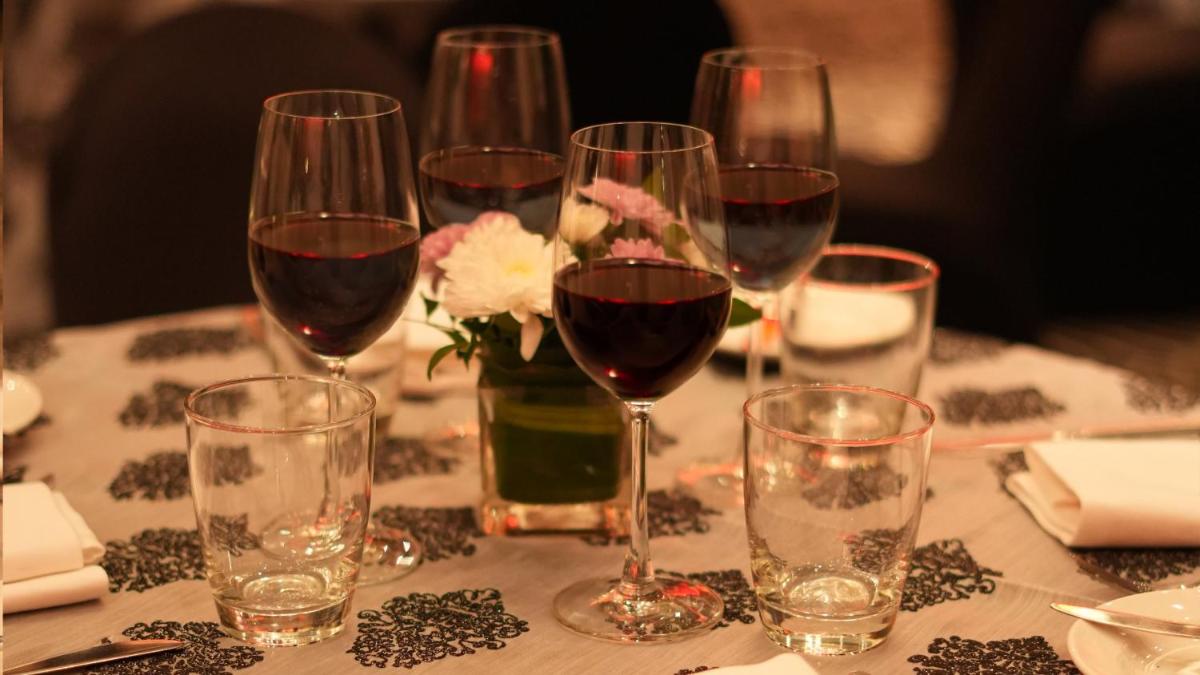 a table with wine glasses and a vase of flowers at InterContinental Marine Drive Mumbai by IHG in Mumbai