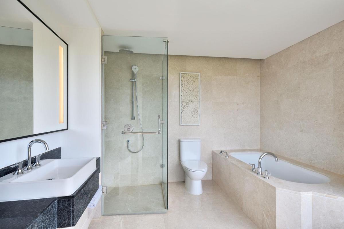 a bathroom with a shower and a toilet and a sink at The Westin Mumbai Powai Lake in Mumbai