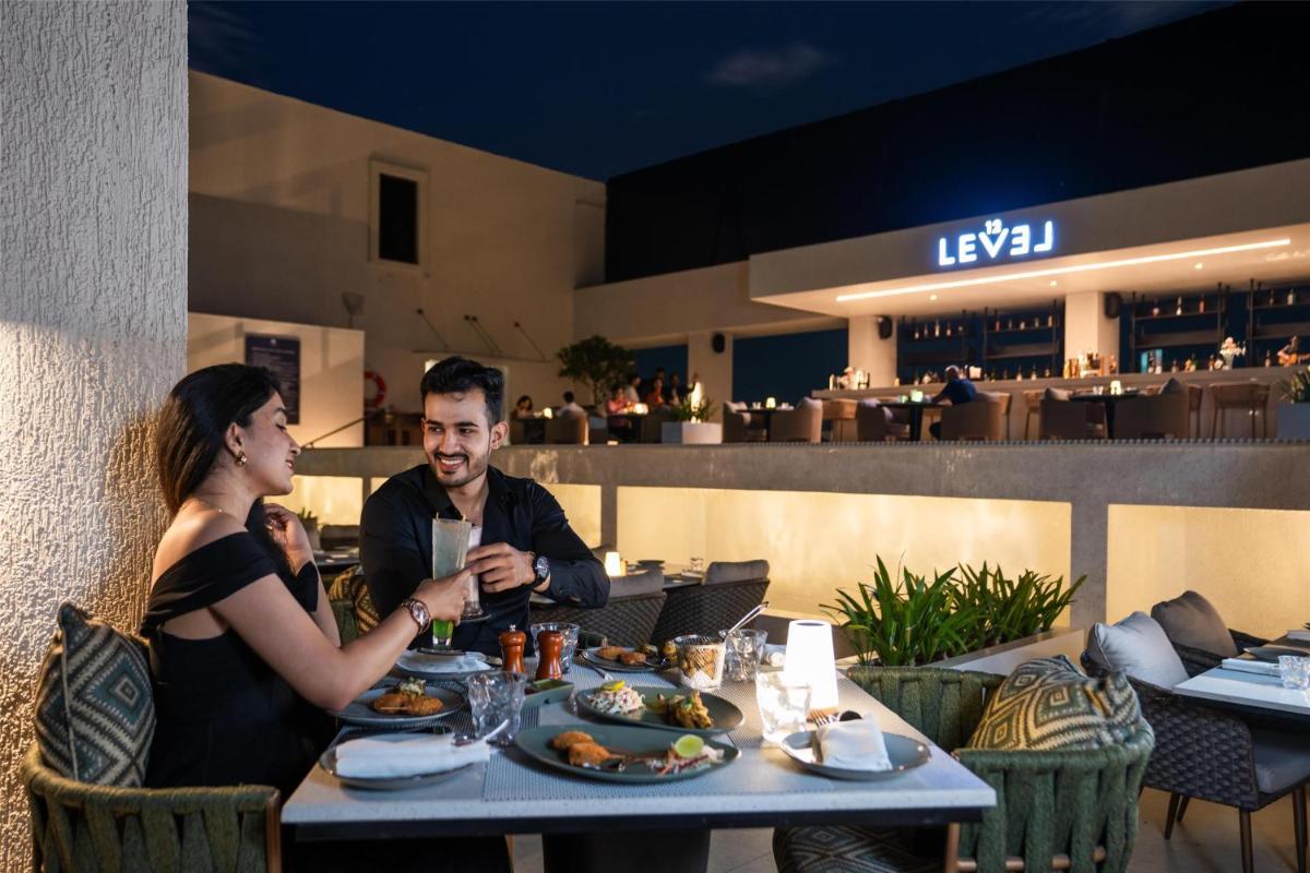 a man and woman sitting at a table in a restaurant at DoubleTree by Hilton-Pune Chinchwad in Pune