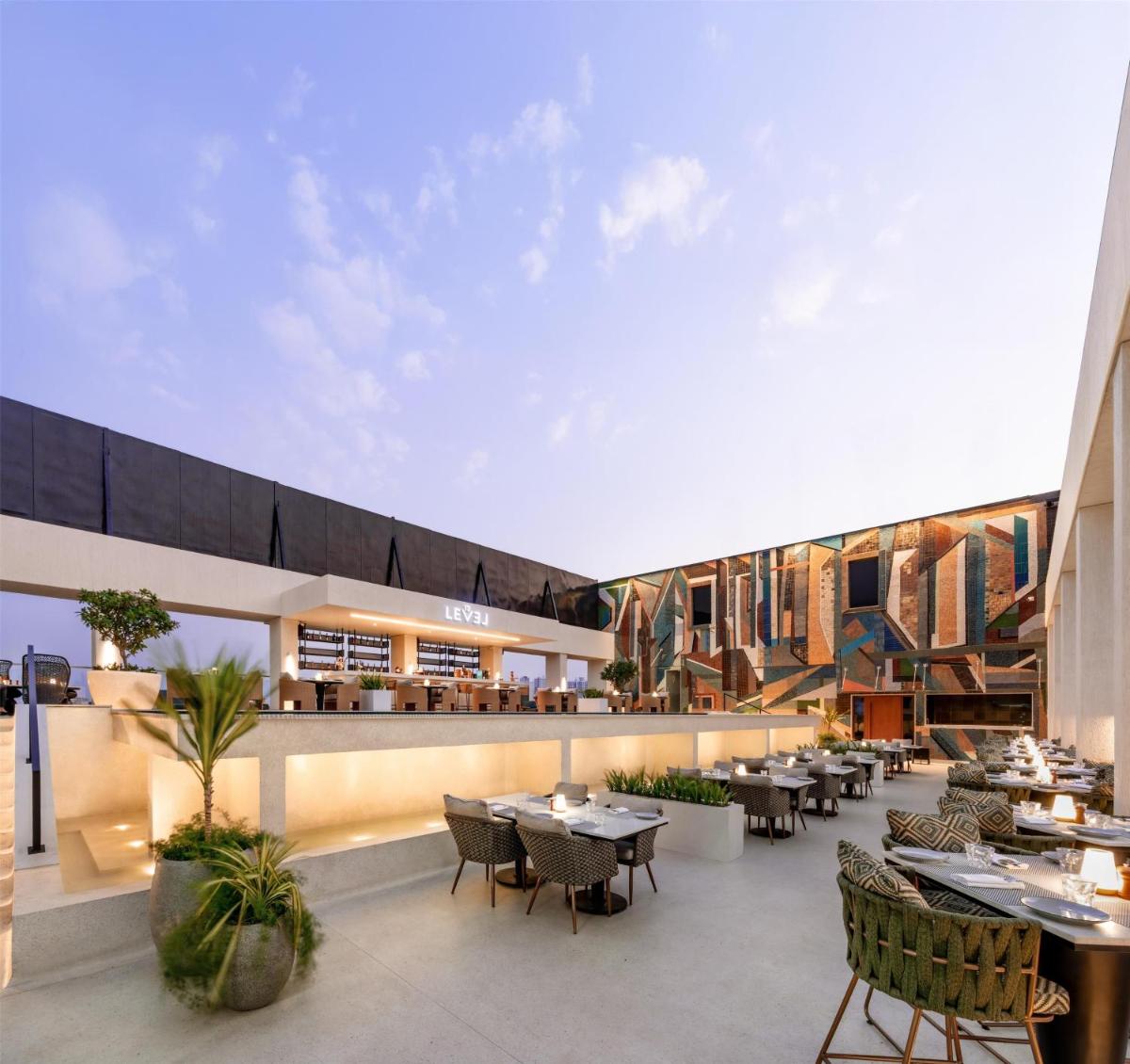 a view of a restaurant with tables and chairs at DoubleTree by Hilton-Pune Chinchwad in Pune