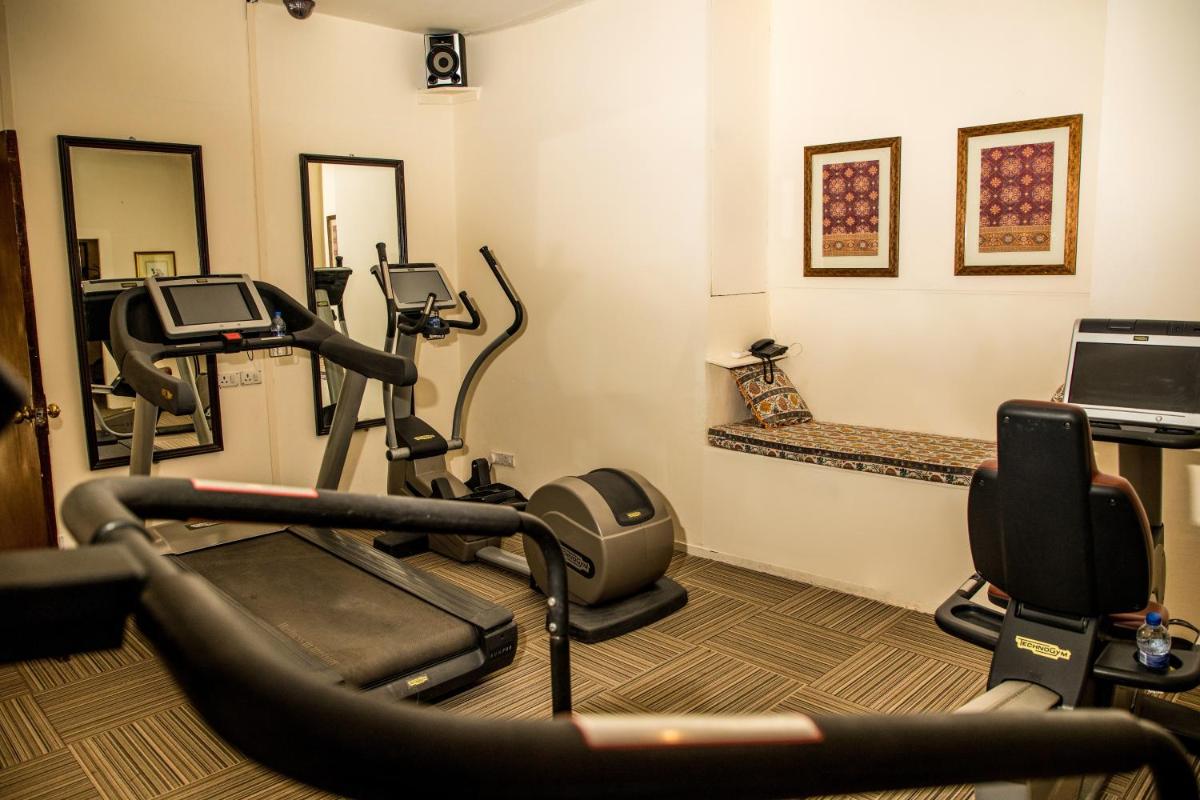 a gym with cardio equipment in a room at The Lalit Laxmi Vilas Palace in Udaipur