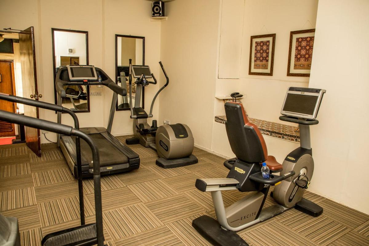 a gym with treadmills and ellipticals in a room at The Lalit Laxmi Vilas Palace in Udaipur