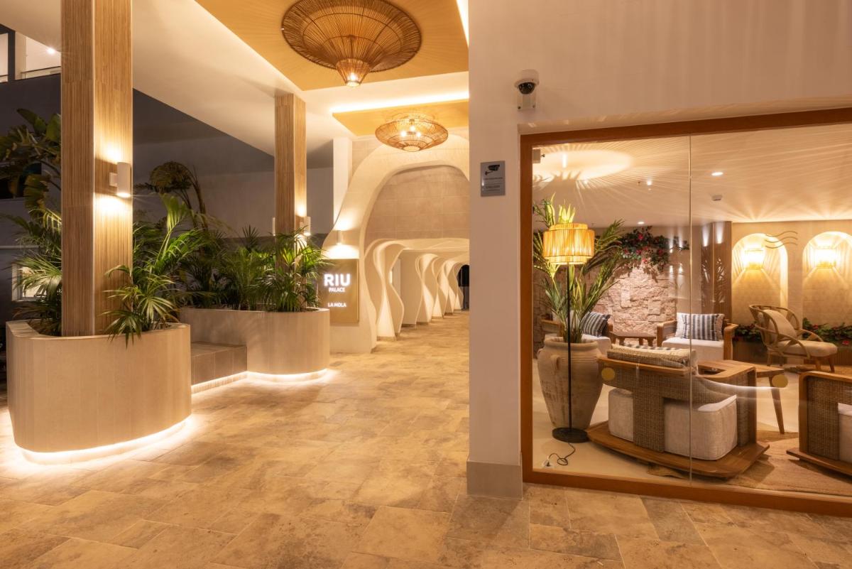 un vestíbulo con macetas en una tienda en Hotel Riu Palace La Mola, en Playa de Migjorn