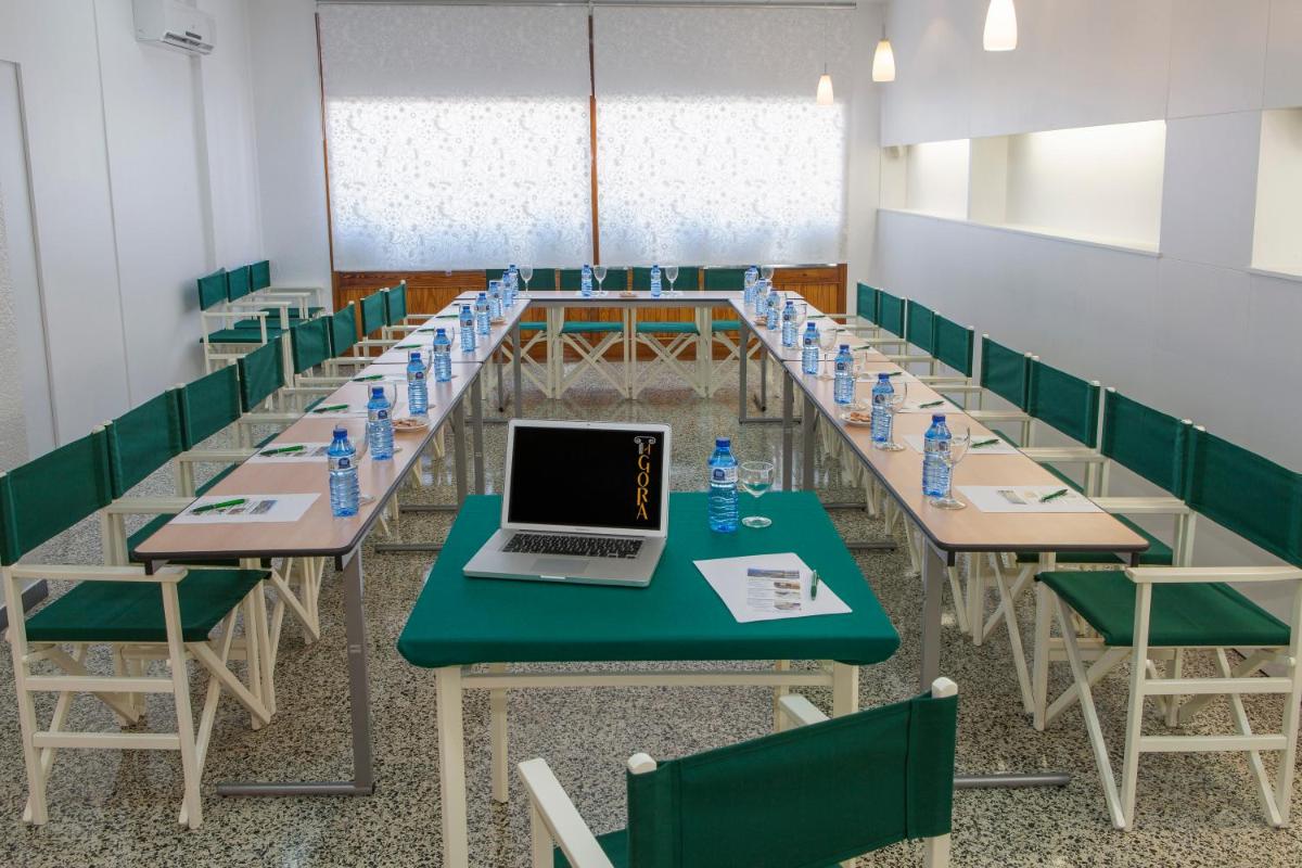 Un aula con filas de mesas con una computadora portátil encima. en Hotel Spa Porto Cristo, en Port de la Selva 116 fotos más