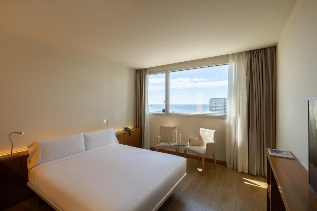Un dormitorio con una gran cama blanca y una ventana. en Hotel SB Diagonal Zero 4 Sup, en Barcelona