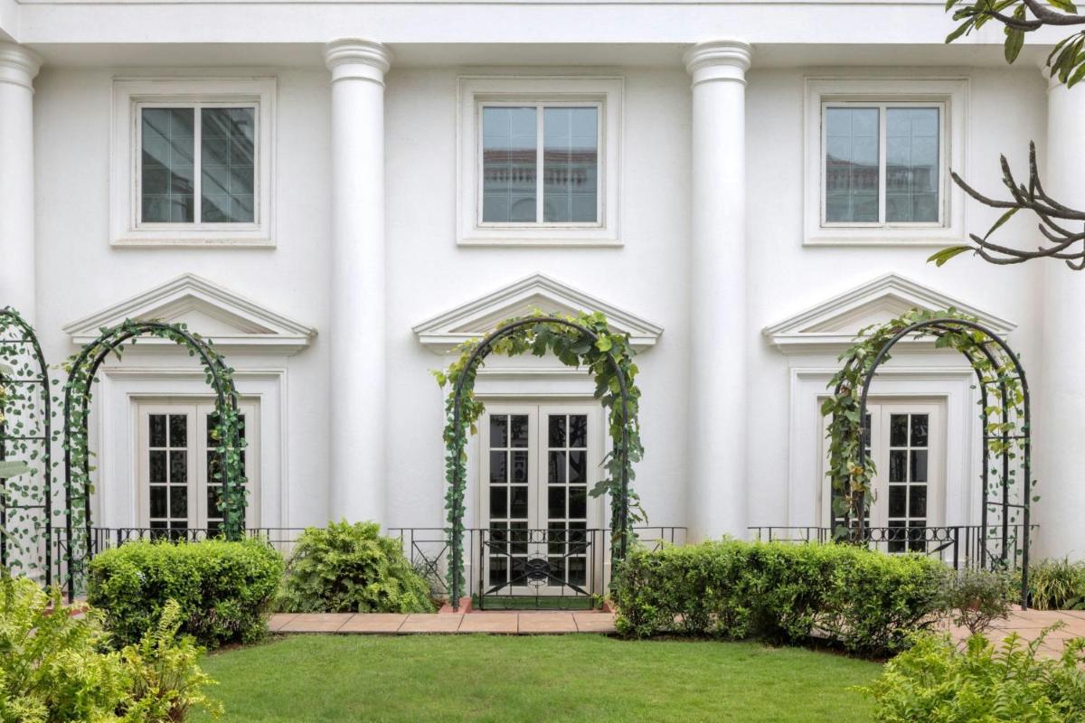 a white house with white columns and ivy at ITC Windsor, a Luxury Collection Hotel, Bengaluru in Bengaluru a white house with white columns and ivy at ITC Windsor, a Luxury Collection Hotel, Bengaluru in Bengaluru