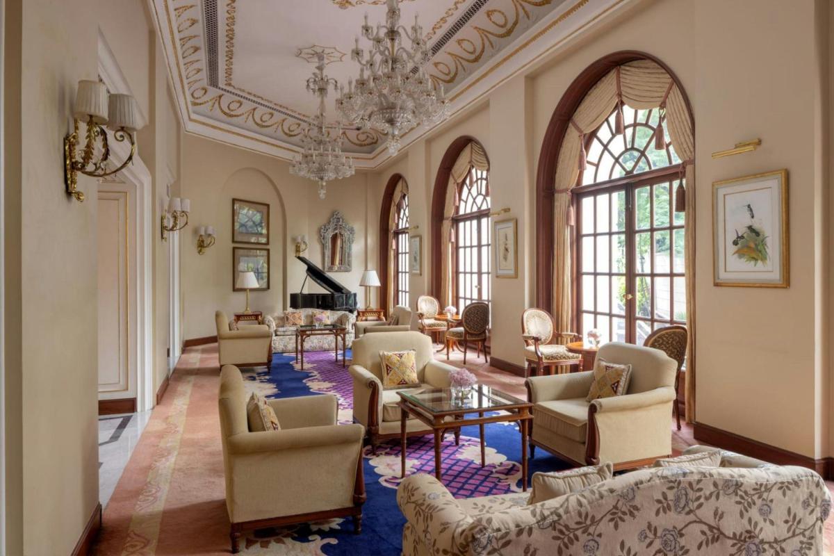 a large living room with chairs and a chandelier at ITC Windsor, a Luxury Collection Hotel, Bengaluru in Bengaluru a large living room with chairs and a chandelier at ITC Windsor, a Luxury Collection Hotel, Bengaluru in Bengaluru