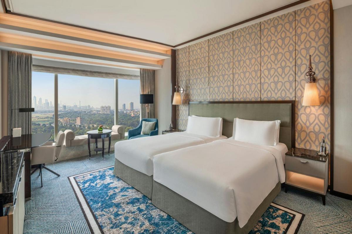 a hotel room with a large bed and a desk at The St. Regis Mumbai in Mumbai