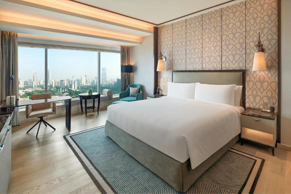 a hotel room with a large bed and a desk at The St. Regis Mumbai in Mumbai