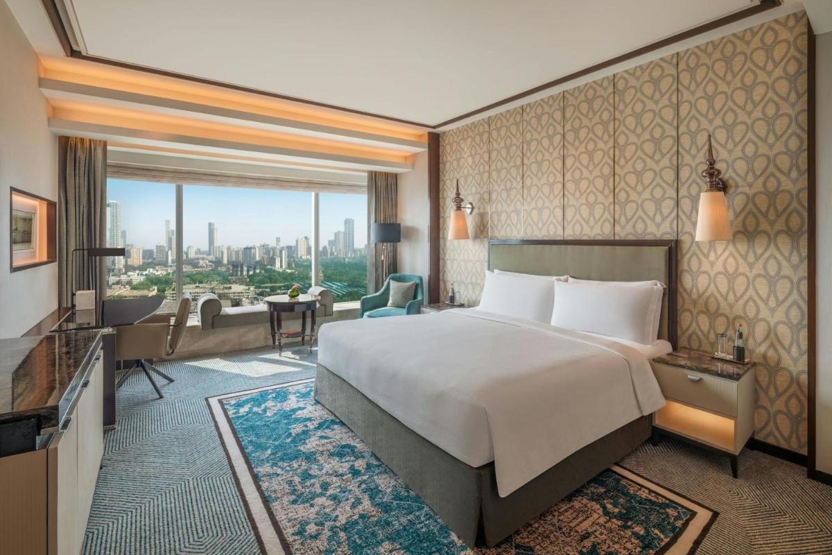 a hotel room with a bed and a living room at The St. Regis Mumbai in Mumbai