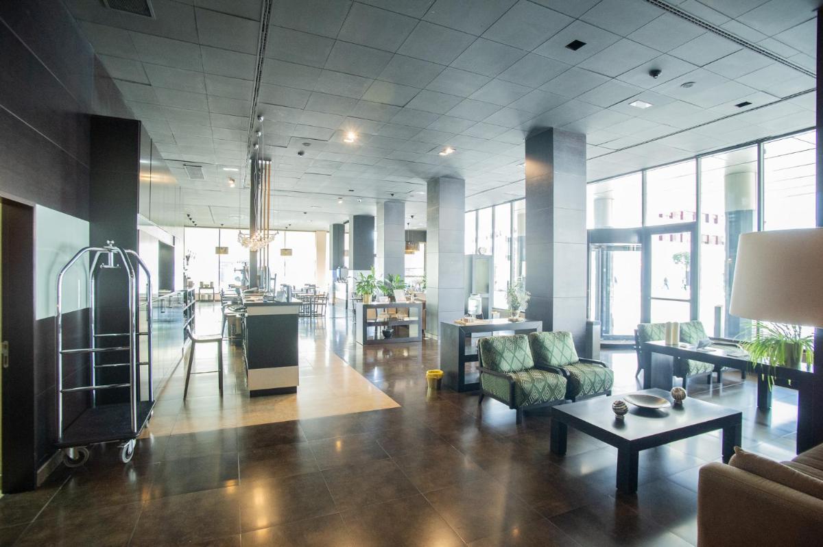 una sala de estar con un sofá y una mesa en AZZ Asturias LangreHotel & Spa, en Langreo