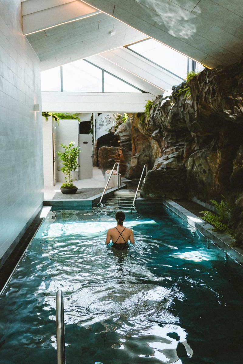 un homme assis dans une piscine dans une maison dans l'établissement Le Berceau de La Source, à Bagnères-de-Bigorre