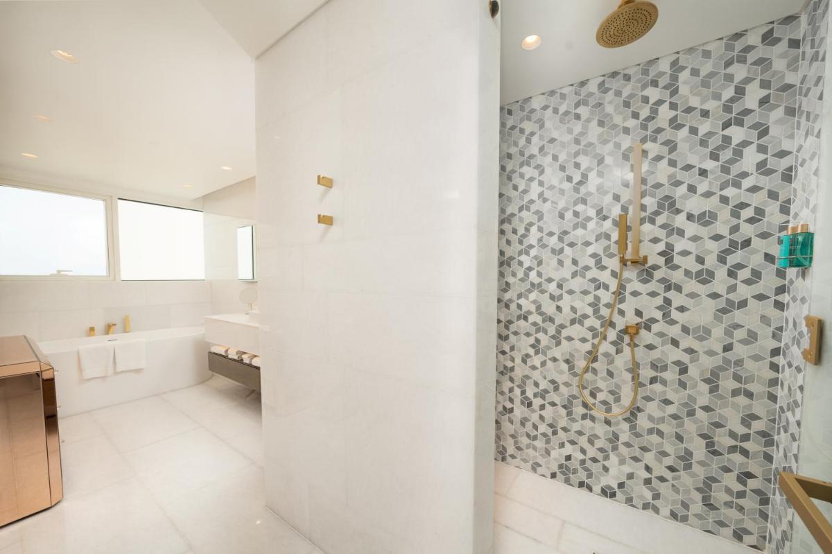 a bathroom with a shower and a tile wall at FIVE Palm Jumeirah Dubai in Dubai