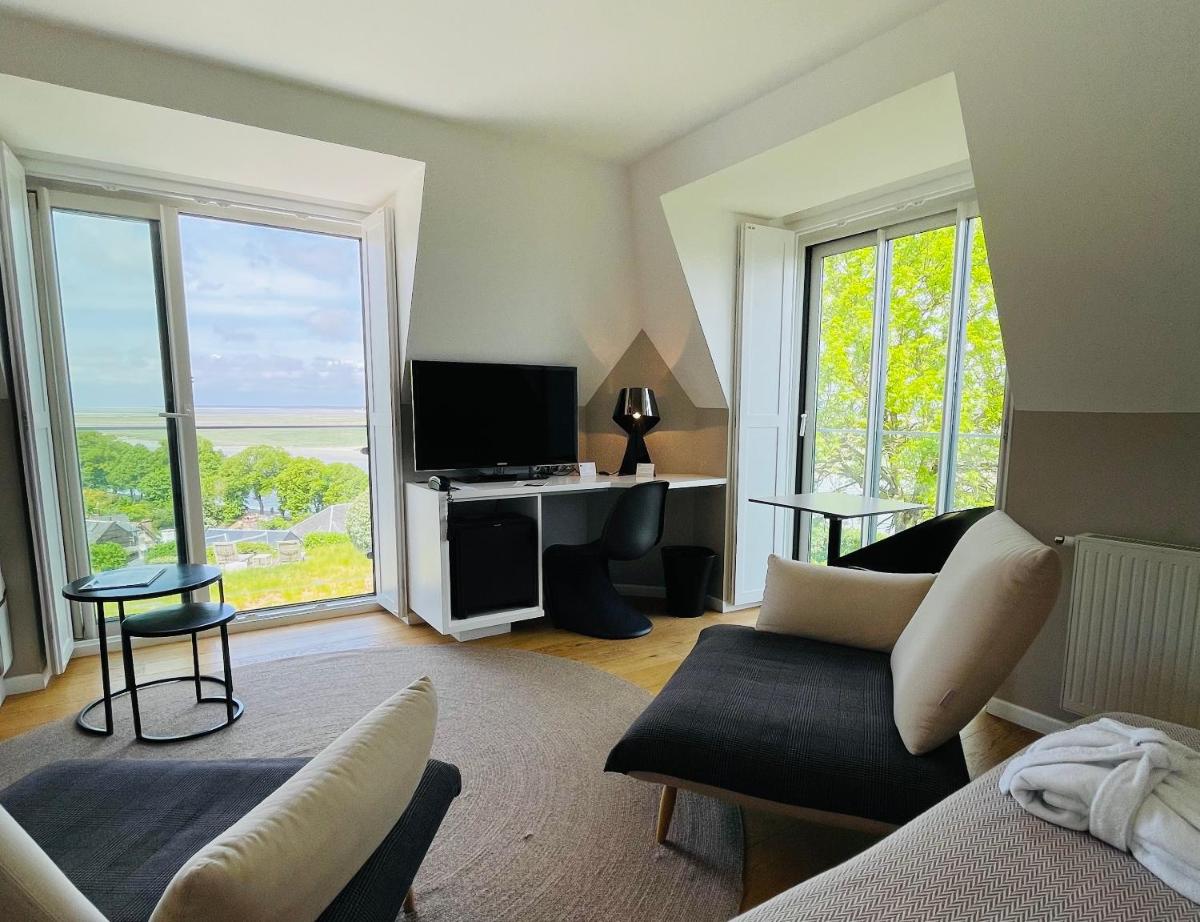 un salon avec un canapé et une télévision dans l'établissement Hôtel - Spa Les Corderies, à Saint-Valery-sur-Somme