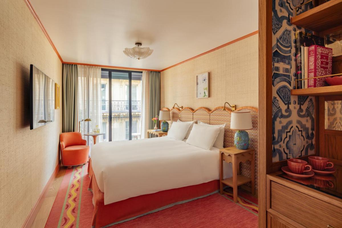 une chambre d'hôtel avec un lit et un balcon dans l'établissement La Fantaisie, à Paris