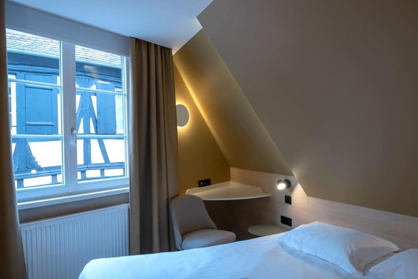 une chambre avec un lit et une fenêtre dans l'établissement Logis Hôtel Restaurant Au Cerf d'Or, à Strasbourg
