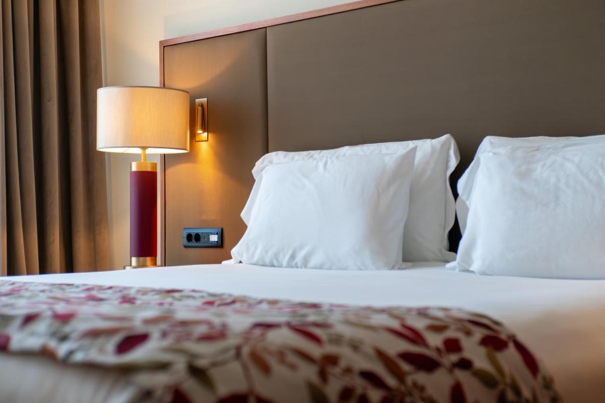 Uma cama ou camas num quarto em Boeira Garden Hotel Porto Gaia, Curio Collection by Hilton