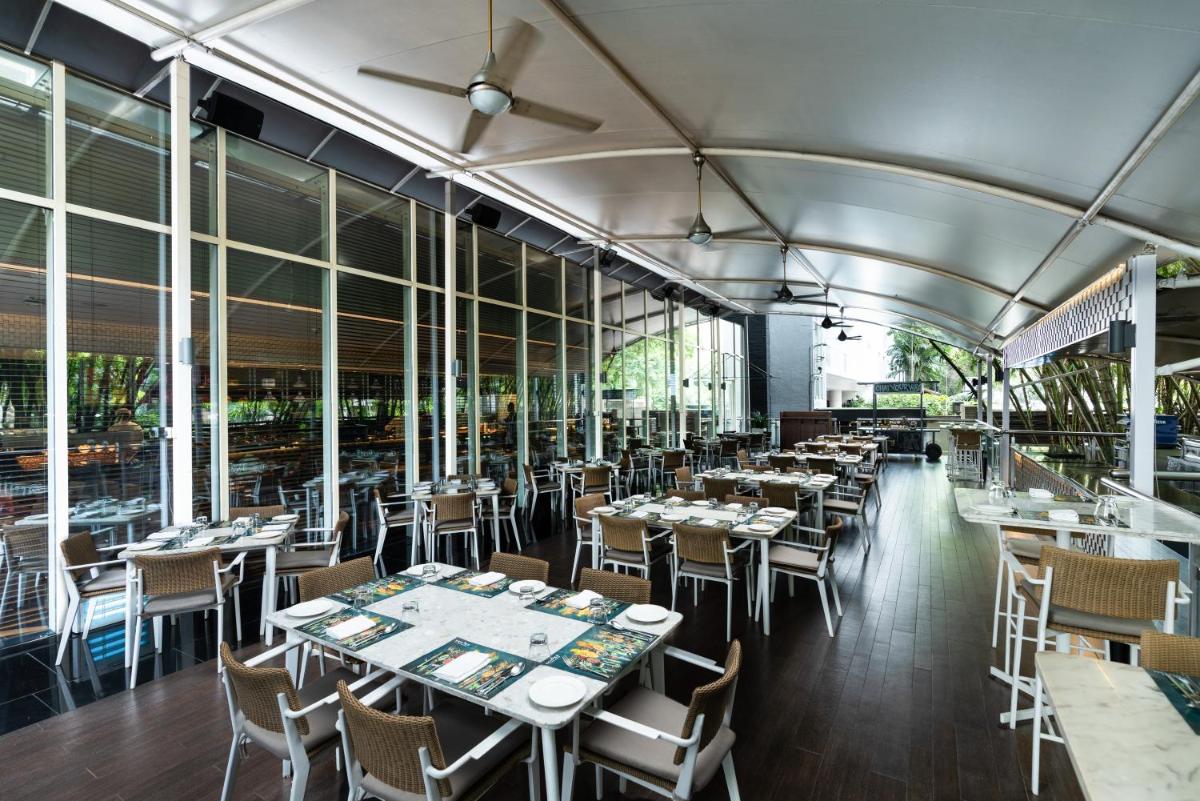 a restaurant with tables and chairs and windows at Marriott Suites Pune in Pune
