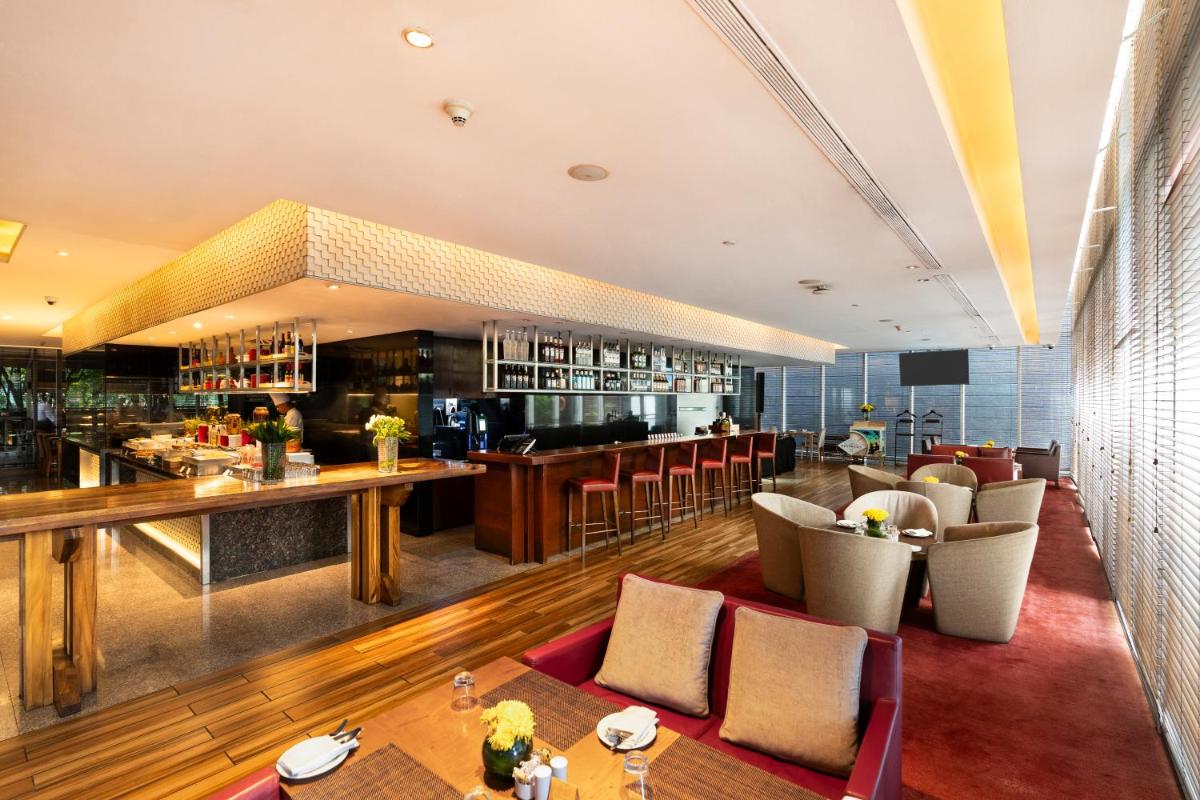 a restaurant with a bar and some chairs and tables at Marriott Suites Pune in Pune