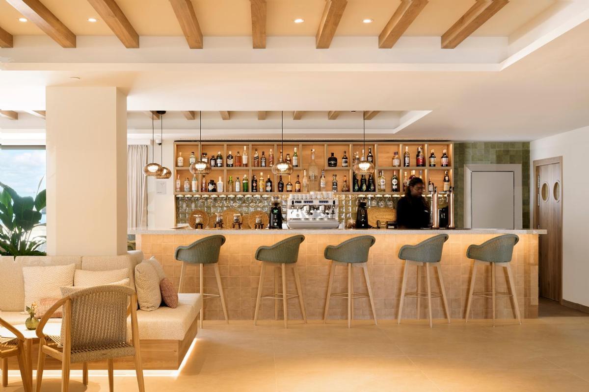 un bar en una habitación con sofá y sillas en Iberostar Selection Es Trenc -New Opening-, en Colonia de Sant Jordi