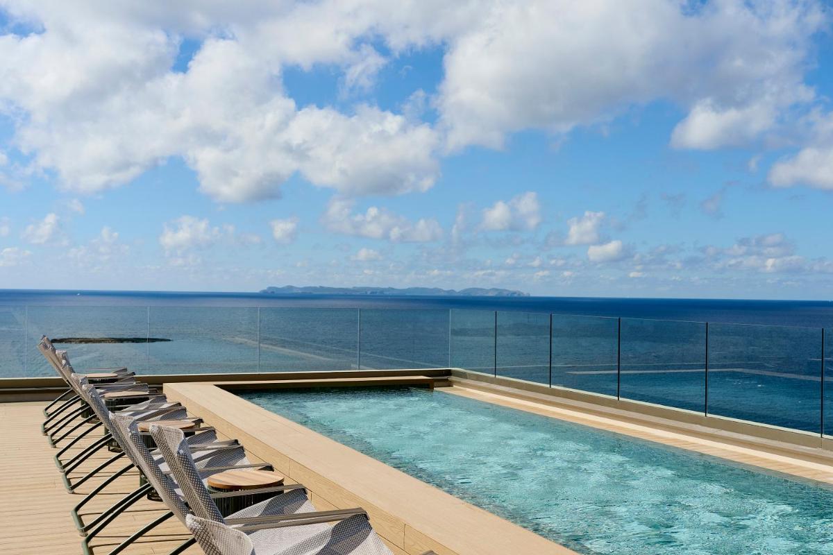una piscina en un balcón con sillas y el océano en Iberostar Selection Es Trenc -New Opening-, en Colonia de Sant Jordi