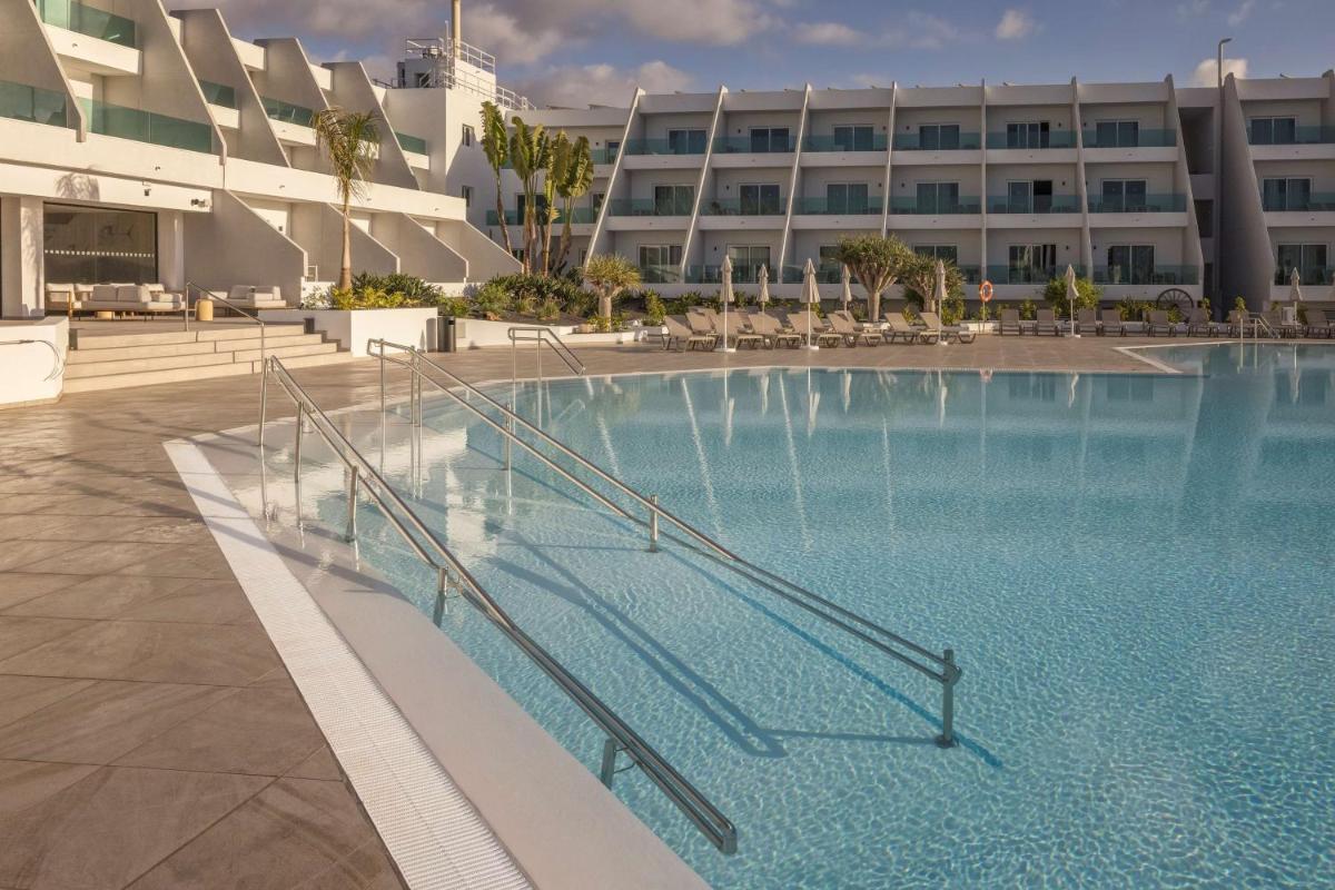 una gran piscina frente a un edificio en Radisson Blu Resort, Lanzarote Adults Only, en Costa Teguise