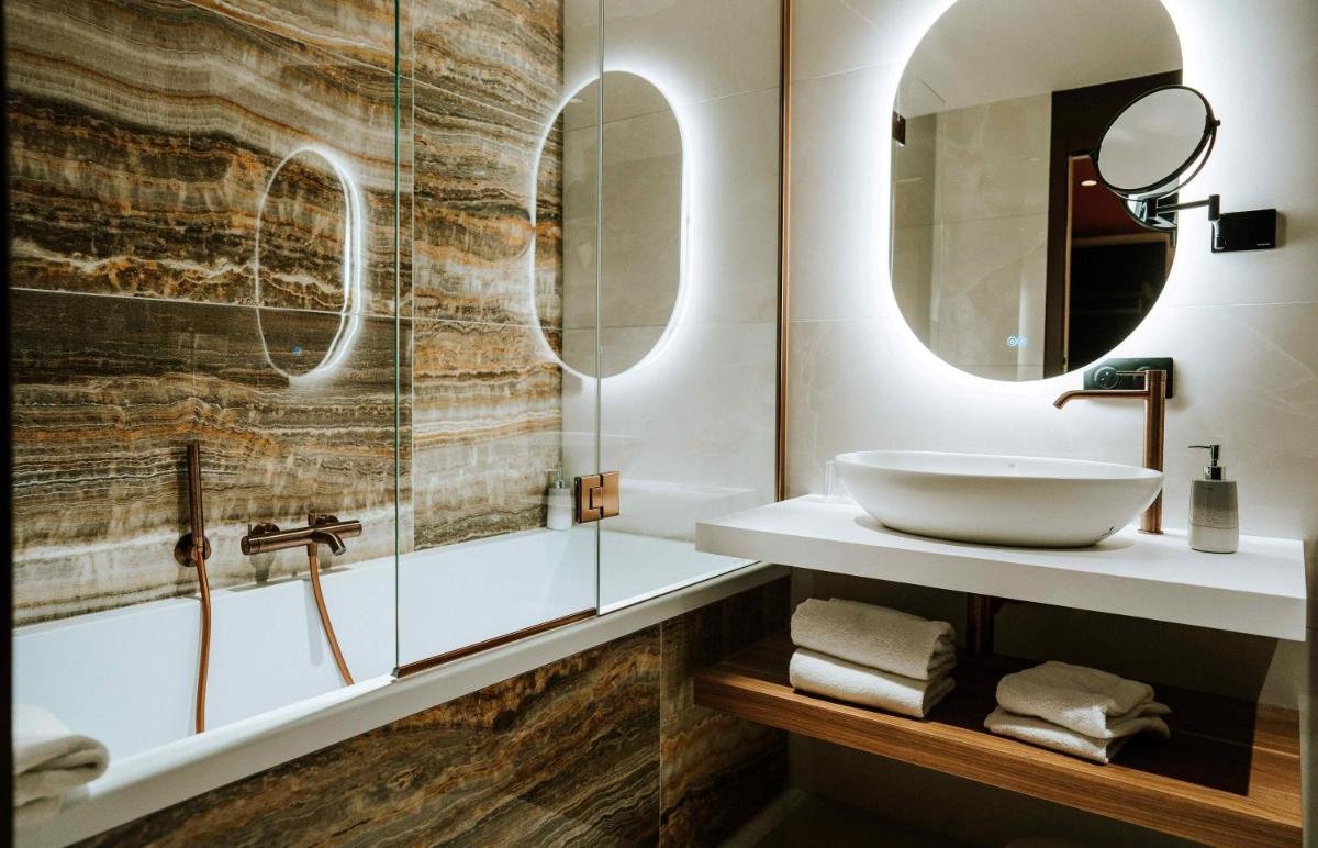 une salle de bain avec un lavabo et un miroir dans l'établissement Hôtel Fesch & Spa, à Ajaccio