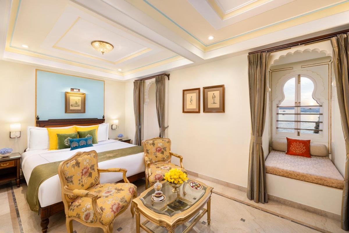 a hotel room with a bed and a table and chairs at Taj Fateh Prakash Palace Udaipur in Udaipur