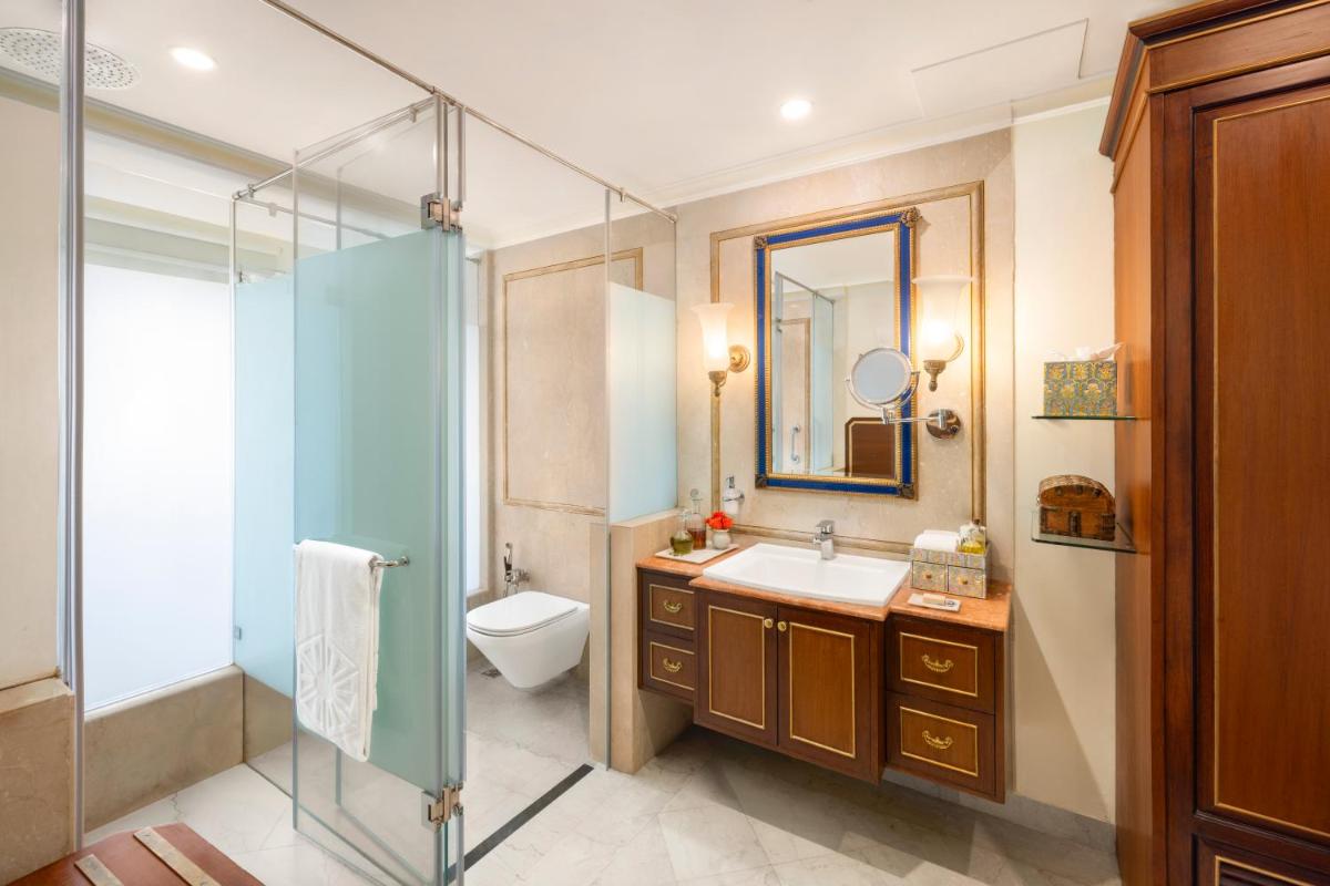 a bathroom with a sink and a toilet and a mirror at Taj Fateh Prakash Palace Udaipur in Udaipur