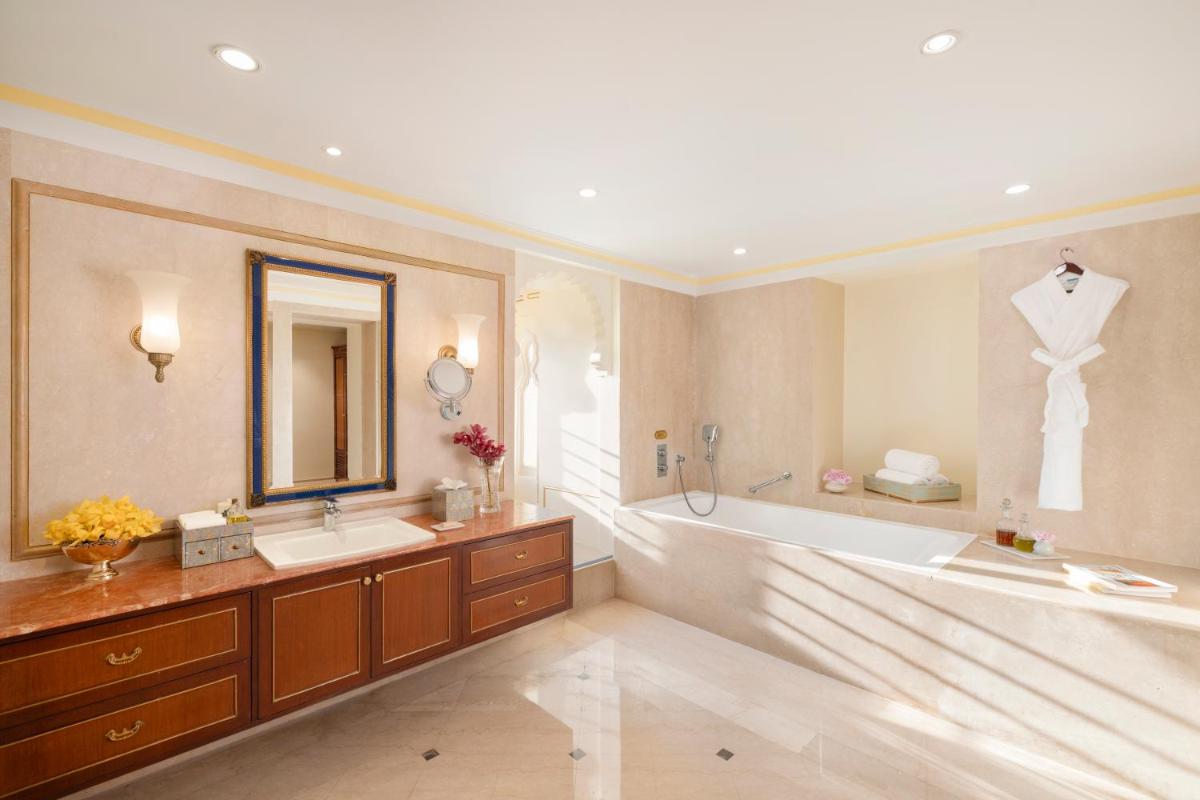 a bathroom with a large tub and a large mirror at Taj Fateh Prakash Palace Udaipur in Udaipur