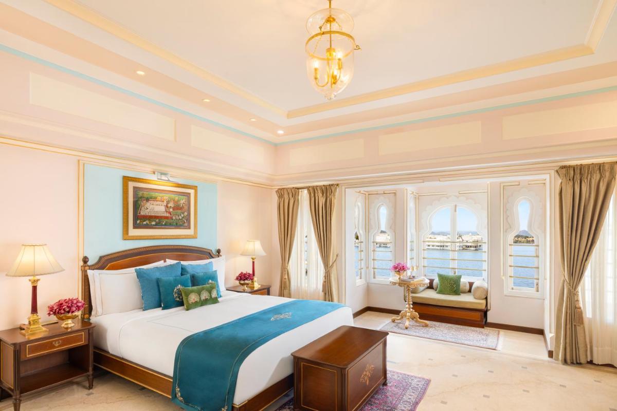 a bedroom with a large bed and a chandelier at Taj Fateh Prakash Palace Udaipur in Udaipur