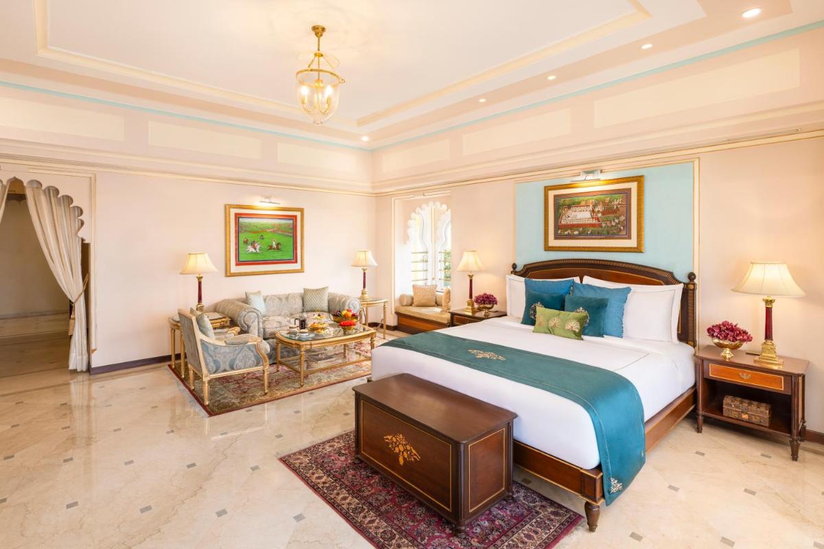 a bedroom with a large bed and a living room at Taj Fateh Prakash Palace Udaipur in Udaipur