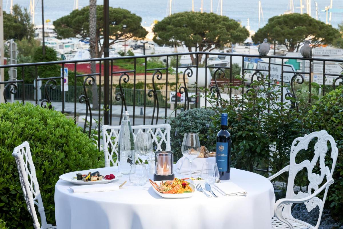 - une table blanche avec de la nourriture et une bouteille de vin dans l'établissement Hôtel L'Abbaye, à Calvi