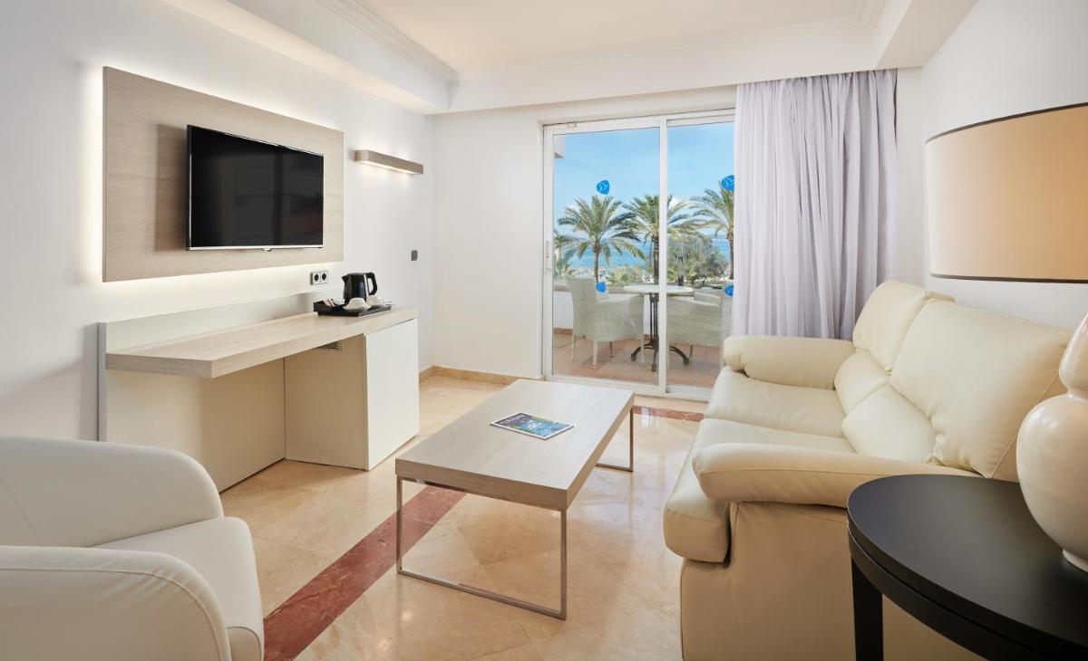 Una sala de estar con un sofá y un televisor. en Grupotel Acapulco Playa - Adults Only, en Playa de Palma