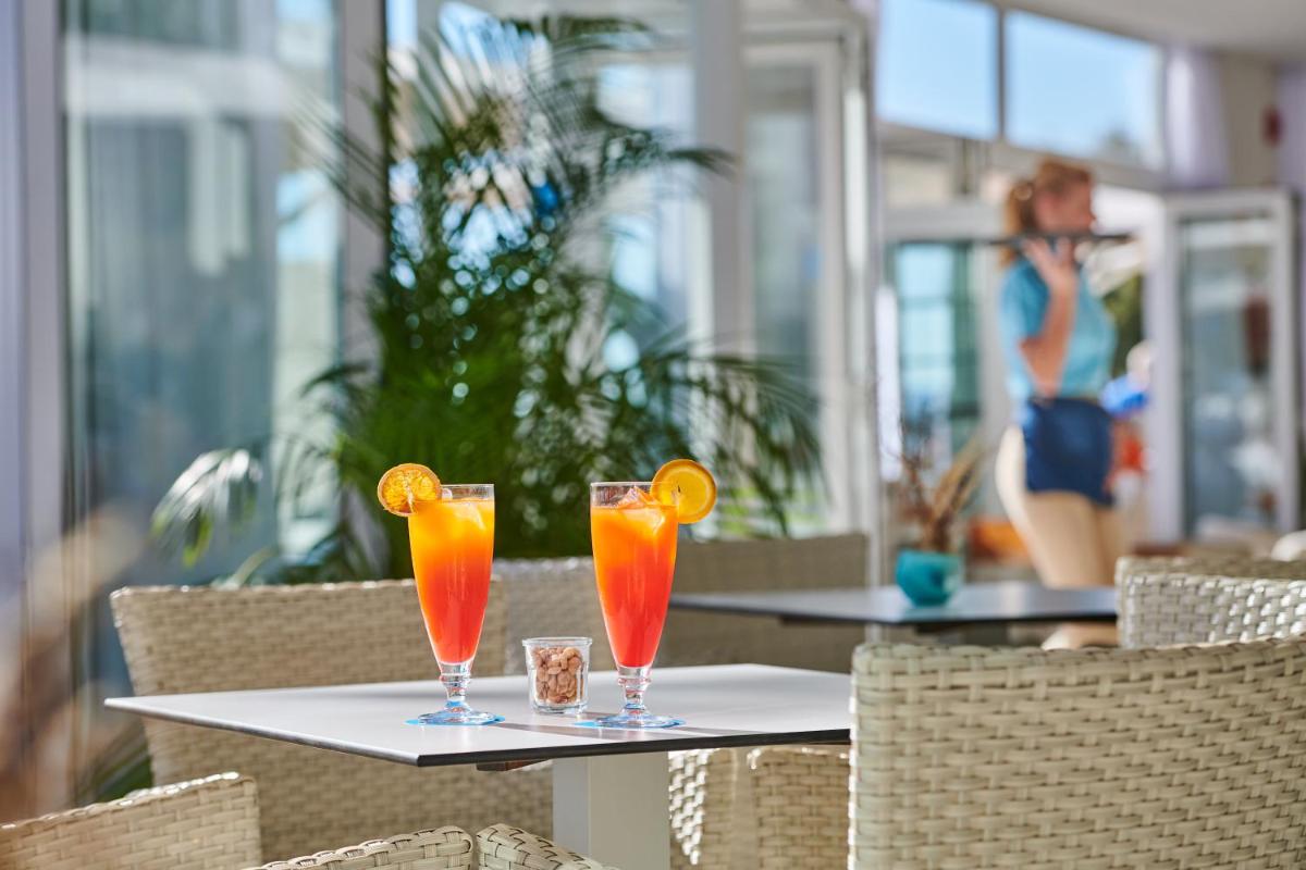 Dos vasos de jugo de naranja sobre una mesa en un restaurante. en Grupotel Acapulco Playa - Adults Only, en Playa de Palma