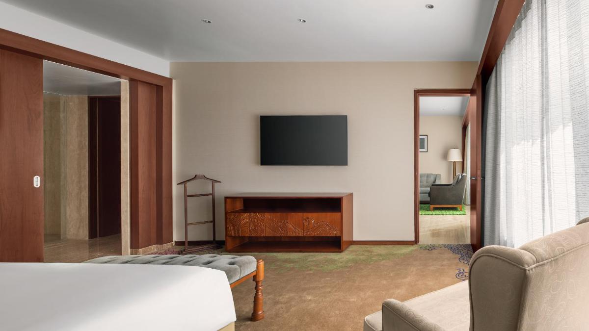 a living room with a flat screen tv on a wall at Park Hyatt Chennai in Chennai