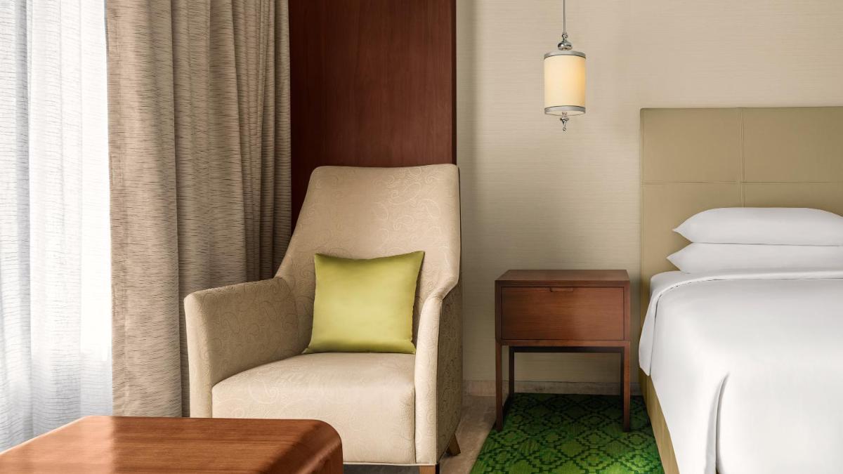 a room with a chair with a green pillow on it at Park Hyatt Chennai in Chennai