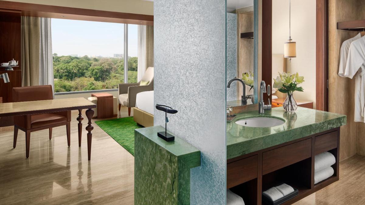 a bathroom with a sink and a room with a table at Park Hyatt Chennai in Chennai