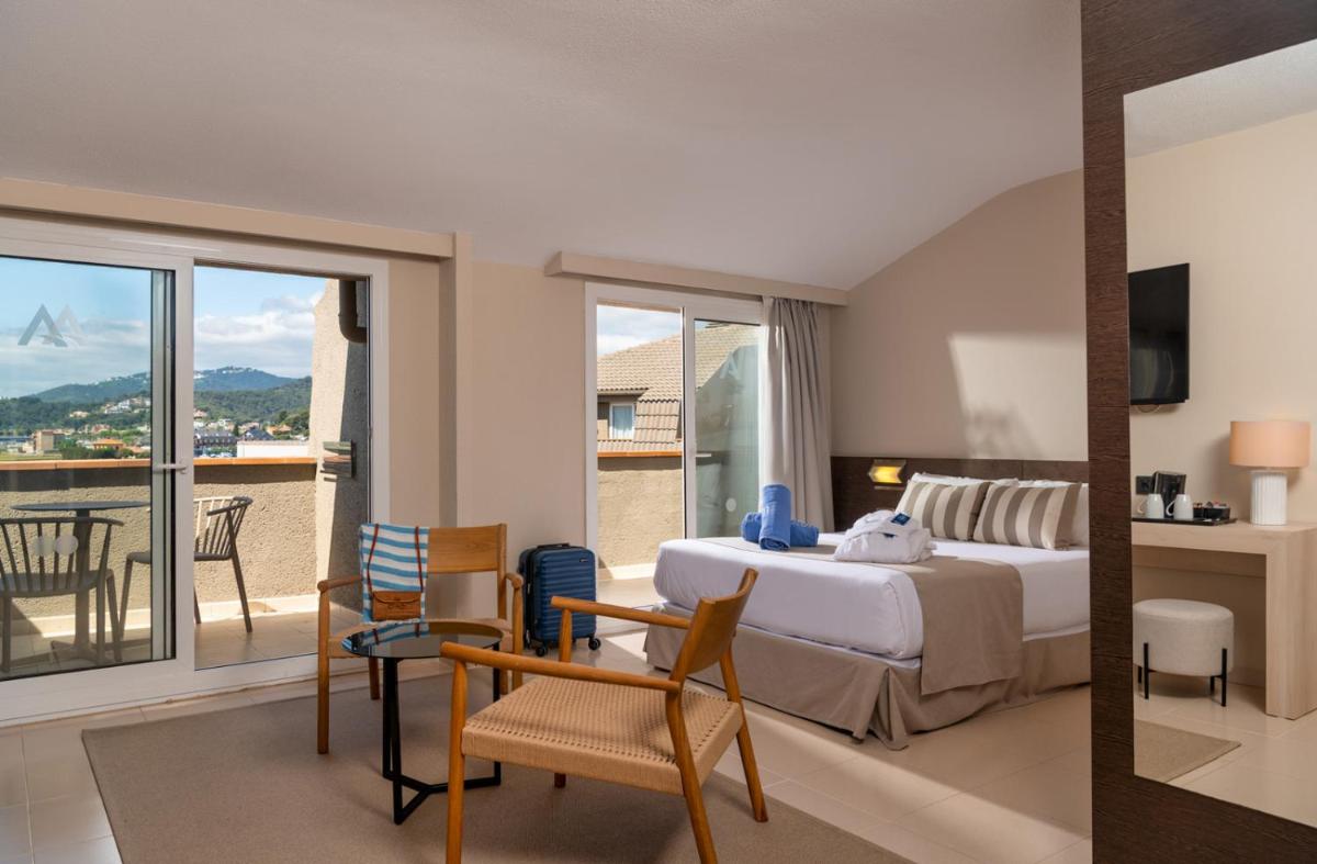 Un dormitorio con una cama y un balcón. en AQUA Hotel The Breeze & Spa - All Inclusive - Adults Only - 4Sup, en Santa Susanna