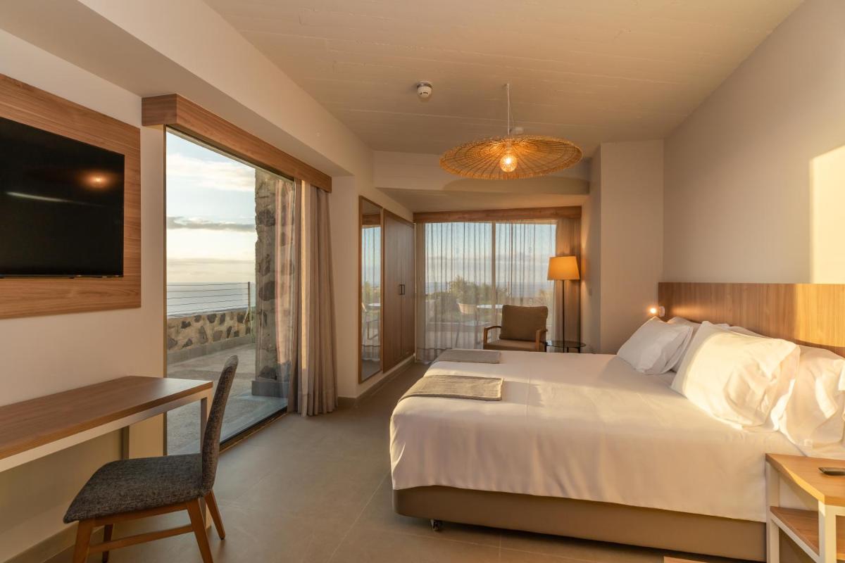 Una habitación de hotel con una cama y una ventana grande. en BANCAL HOTEL and SPA, en San Sebastián de la Gomera
