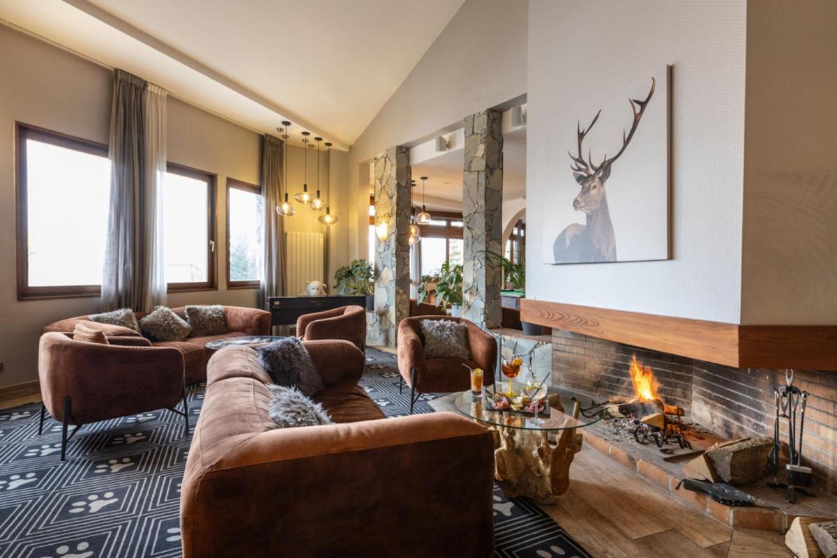 un salon avec des canapés et une cheminée dans l'établissement Royal Ours Blanc Boutique Hôtel & Spa, à L'Alpe-d'Huez