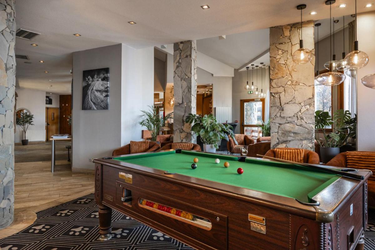 une table de billard dans un salon avec une facture dans l'établissement Royal Ours Blanc Boutique Hôtel & Spa, à L'Alpe-d'Huez