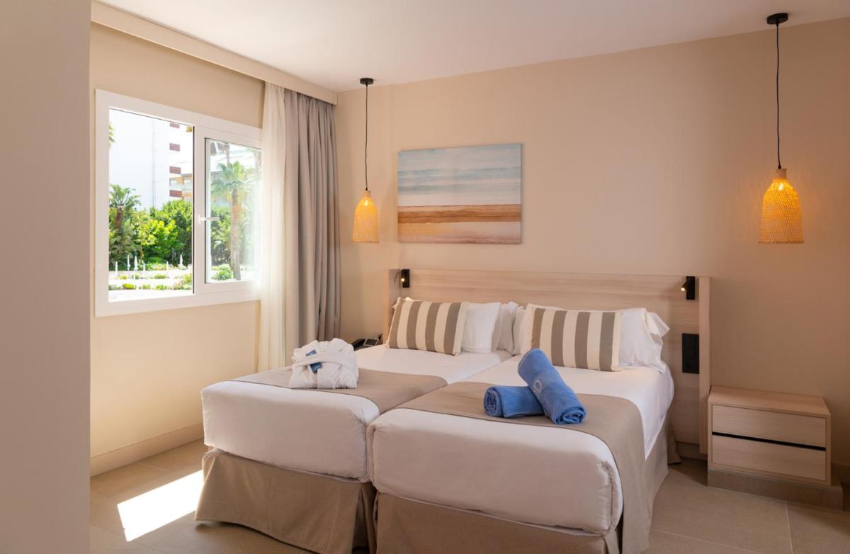 Una habitación de hotel con dos camas y dos ventanas. en AQUA Hotel The Breeze & Spa - All Inclusive - Adults Only - 4Sup, en Santa Susanna