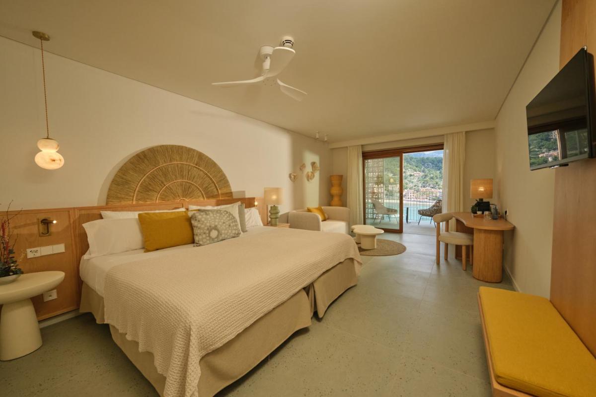 Un dormitorio con una cama grande y una sala de estar. en Salino Port Soller, en Puerto de Sóller