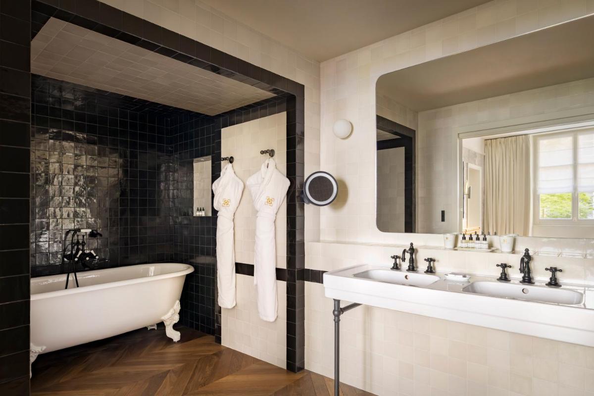 La salle de bains est pourvue de 2 lavabos, d'une baignoire et d'une baignoire. dans l'établissement Le Pavillon de la Reine & Spa, Place des Vosges, à Paris 37 autres photos